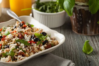 Kırmızı pirinçli moda öğle yemeği, sebze ve sebze karışımı. Ön manzara. Gri ahşap arka planda beyaz kasede servis ediliyor.. 