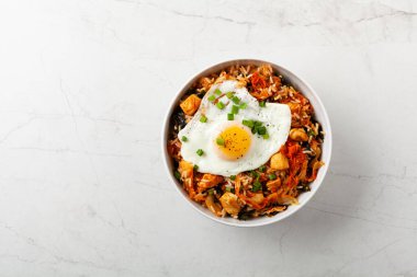 Pirinç ve tavuklu kimçi lahanası. Hafif mermer arka planda beyaz bir kasede servis edilmiş. Üst görünüm.