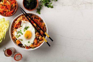 Pirinç ve tavuklu kimçi lahanası. Hafif mermer arka planda beyaz bir kasede servis edilmiş. Üst görünüm.