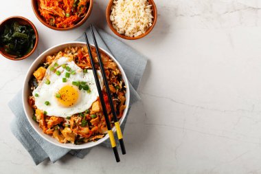 Pirinç ve tavuklu kimçi lahanası. Hafif mermer arka planda beyaz bir kasede servis edilmiş. Üst görünüm.