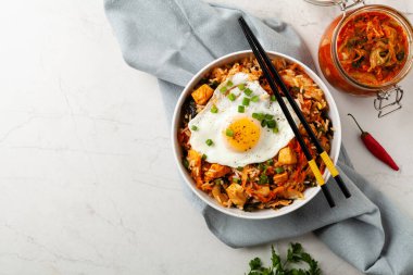 Pirinç ve tavuklu kimçi lahanası. Hafif mermer arka planda beyaz bir kasede servis edilmiş. Üst görünüm.