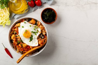 Pirinç ve tavuklu kimçi lahanası. Hafif mermer arka planda beyaz bir kasede servis edilmiş. Üst görünüm.