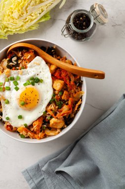 Pirinç ve tavuklu kimçi lahanası. Hafif mermer arka planda beyaz bir kasede servis edilmiş. Üst görünüm.