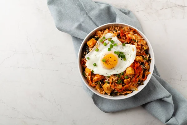 Pirinç ve tavuklu kimçi lahanası. Hafif mermer arka planda beyaz bir kasede servis edilmiş. Üst görünüm.