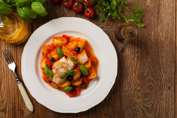 传统上用西班牙语编写鳕鱼 用番茄酱和煮过的土豆 橄榄和罗勒一起食用 顶部视图 — 图库照片