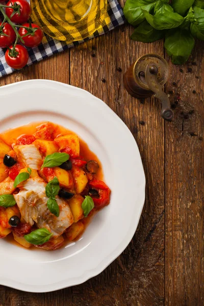 传统上用西班牙语编写鳕鱼 用番茄酱和煮过的土豆 橄榄和罗勒一起食用 顶部视图 — 图库照片