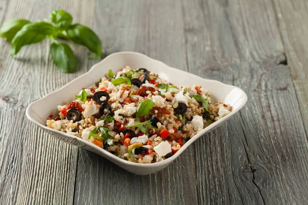 Kırmızı pirinçli moda öğle yemeği, sebze ve sebze karışımı. Ön manzara. Gri ahşap arka planda beyaz kasede servis ediliyor.. 