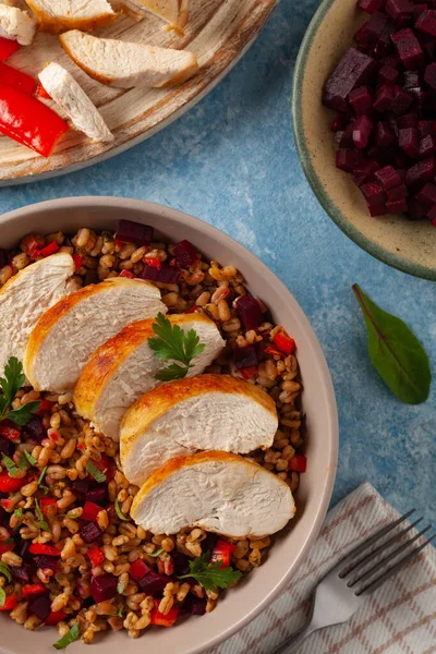 Mısır gevreği, pancar kökü ve tavukla moda bir öğle yemeği. Mavi boyalı arka planda bir kasede servis edilmiş. Üst görünüm. 