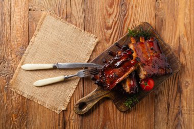 Kızarmış domuz pirzolası ve bbq sosu. Tahta bir tahtanın üzerinde servis edilmiş. Üst görünüm.