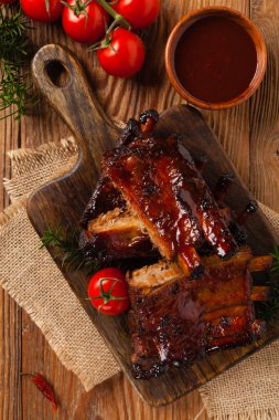 Kızarmış domuz pirzolası ve bbq sosu. Tahta bir tahtanın üzerinde servis edilmiş. Üst görünüm.