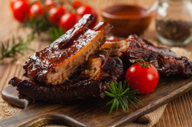 Kızarmış domuz pirzolası ve bbq sosu. Tahta bir tahtanın üzerinde servis edilmiş. Ön görünüm.