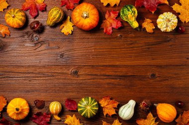 Ahşap arka plan. Sonbahar yaprakları ve balkabakları. Üst görünüm.