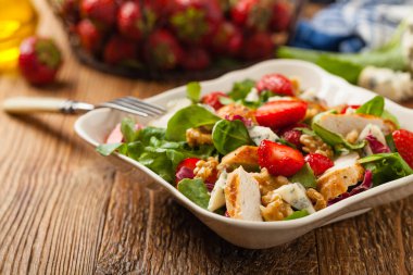 Kızarmış tavuk, mavi peynir, çilek ve cevizli lezzetli salata. Ön görünüm. 