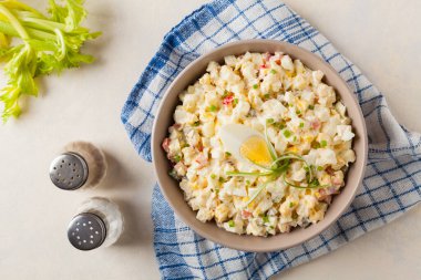Kerevizli, turşulu, biberli ve mayonezli hafif yumurta salatası. Arka planda bir kasede servis edilmiş. Üst görünüm.