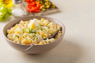 Kerevizli, turşulu, biberli ve mayonezli hafif yumurta salatası. Arka planda bir kasede servis edilmiş. Ön görünüm.