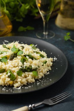 Klasik İtalyan pilavı ve kuşkonmaz. Ön manzara. Koyu mavi arkaplan.