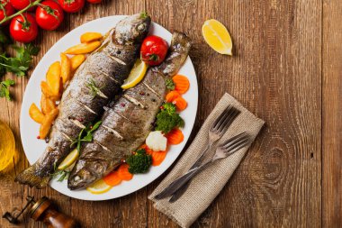 Izgara alabalık. Fırında patatesle servis edilir. Üst görünüm. 