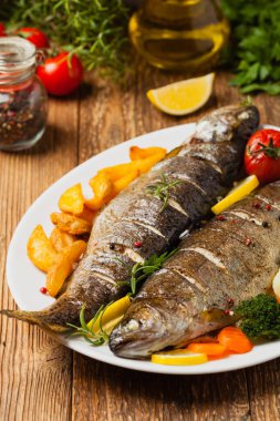 Izgara alabalık. Fırında patatesle servis edilir. Ön görünüm. 