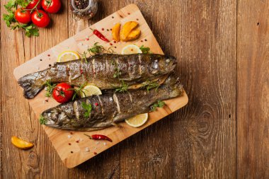 Izgara alabalık. Fırında patatesle servis edilir. Üst görünüm. 