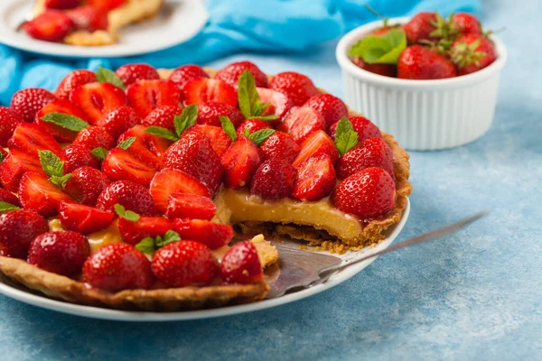 Mavi arka planda çilekli lezzetli bir tart. Ön görünüm.