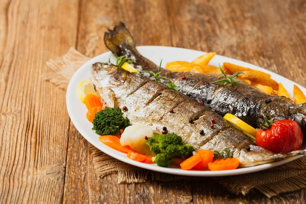 Izgara alabalık. Fırında patatesle servis edilir. Ön görünüm. 