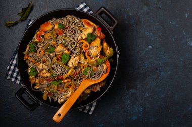 Siyah susamlı buğday eriştesi, tavuk ve sebzeli tavada kızartılmış. Üst görünüm.