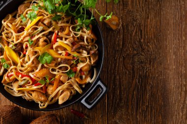 Mangolu kızarmış tavuk ve erişteli hindistan cevizi sütü. Bir tavada hazır. Üst görünüm. 