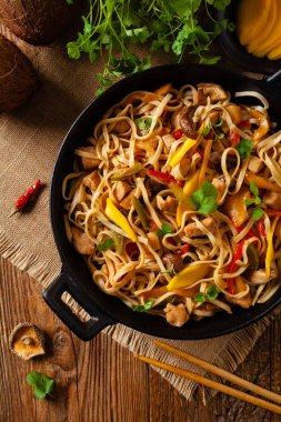 Mangolu kızarmış tavuk ve erişteli hindistan cevizi sütü. Bir tavada hazır. Üst görünüm. 