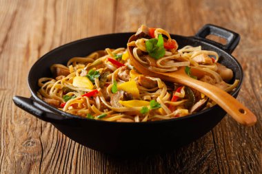 Mangolu kızarmış tavuk ve erişteli hindistan cevizi sütü. Bir tavada hazır. Ön görünüm. 