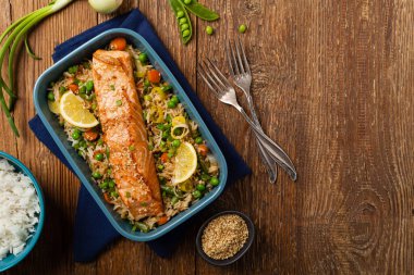 Asya yemeği. Pirinç ve sebzeli kızarmış somon. Susam tohumları serpiştirilmiş. Üst Manzara. Doğal arkaplan. 