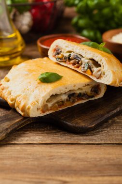 Mantarlı ve jambonlu İtalyan calzone. Ön görünüm. 