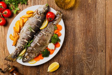 Izgara alabalık. Fırında patatesle servis edilir. Üst görünüm. 