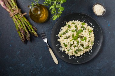 Klasik İtalyan pilavı ve kuşkonmaz. Üst Manzara. Koyu mavi arkaplan.