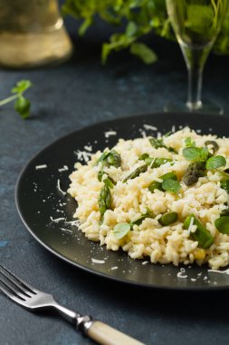 Klasik İtalyan pilavı ve kuşkonmaz. Ön manzara. Koyu mavi arkaplan.
