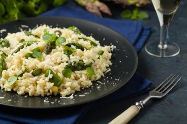 Klasik İtalyan pilavı ve kuşkonmaz. Ön manzara. Koyu mavi arkaplan.