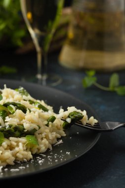 Klasik İtalyan pilavı ve kuşkonmaz. Ön manzara. Koyu mavi arkaplan.