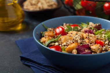 Kinoalı salata, avokado ve tavuk. Ön manzara. Mavi bir kasede servis edildi..