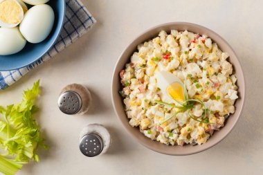 Kerevizli, turşulu, biberli ve mayonezli hafif yumurta salatası. Arka planda bir kasede servis edilmiş. Üst görünüm.