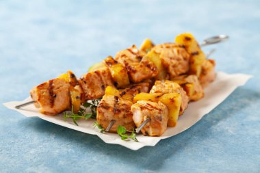 Somon ve ananaslı ızgara şiş kebap. Kağıt denemede kullanıldı. Mavi boyalı arkaplan.