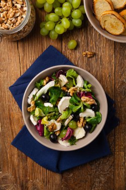 Keçi peynirli, üzümlü ve cevizli İtalyan bahar salatası. Kızarmış ekmekle servis edilir. Üst görünüm. 