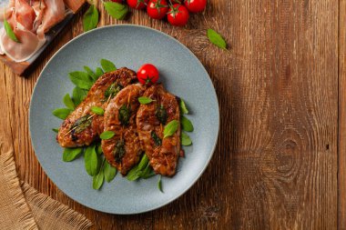 Saltimbocca. Adaçayı ve Parma jambonlu dana şnitzel. İtalyan spesiyali. Üst görünüm.