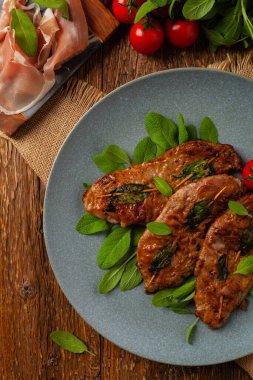 Saltimbocca. Adaçayı ve Parma jambonlu dana şnitzel. İtalyan spesiyali. Üst görünüm.