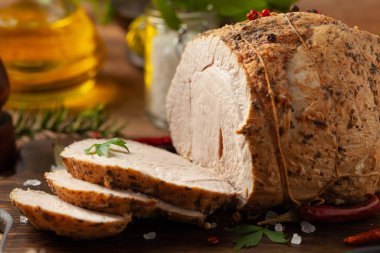 Çıtır, pişmiş jambon. Ahşap bir tahtada baharatlarla servis edilir. Ön görünüm.