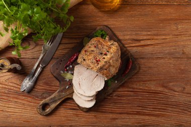 Çıtır, pişmiş jambon. Ahşap bir tahtada baharatlarla servis edilir. Üst görünüm.