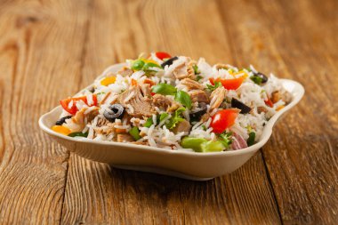 İtalyan ton balığı salatası, pilav, zeytin ve kapari. Ön manzara. Doğal ahşap zemin.