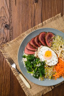 Lahanalı Kore bifteği, ıspanak ve kızarmış yumurta. Üst görünüm.