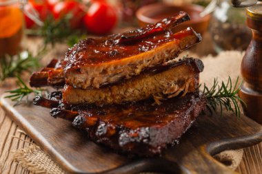 Kızarmış domuz pirzolası ve bbq sosu. Tahta bir tahtanın üzerinde servis edilmiş. Ön görünüm.