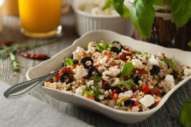 Kırmızı pirinçli moda öğle yemeği, sebze ve sebze karışımı. Ön manzara. Gri ahşap arka planda beyaz kasede servis ediliyor.. 