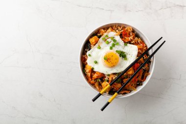 Pirinç ve tavuklu kimçi lahanası. Hafif mermer arka planda beyaz bir kasede servis edilmiş. Üst görünüm.