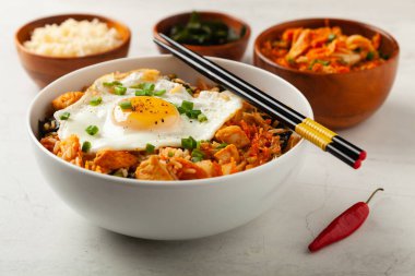 Pirinç ve tavuklu kimçi lahanası. Hafif mermer arka planda beyaz bir kasede servis edilmiş. Ön görünüm.